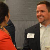 An alumnus shakes hands with another alumna at the Academic Major Fair.